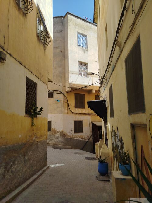 Free Explore a narrow, sunlit alleyway with historic architecture in a quaint town. Stock Photo