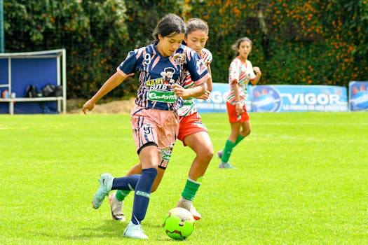 Women engaging in a competitive soccer match on a vibrant green field.