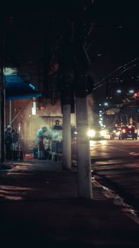 Moody evening street scene showcasing a smoky food stall and vibrant city lights.