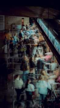 Dynamic scene of passengers rushing through subway turnstiles in an urban area.
