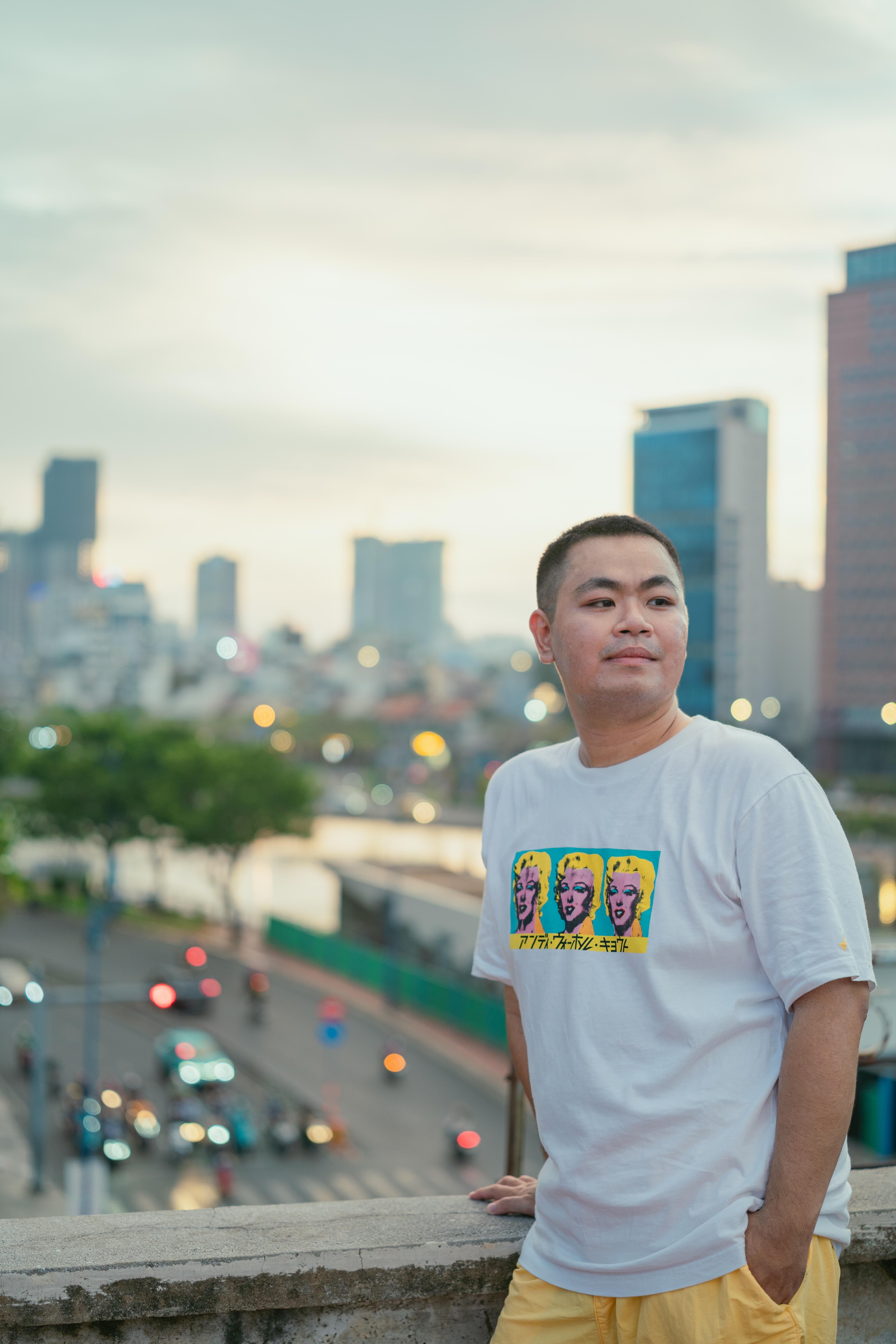 Man enjoying a relaxed moment in urban Ho Chi Minh City with blurred cityscape in the background.