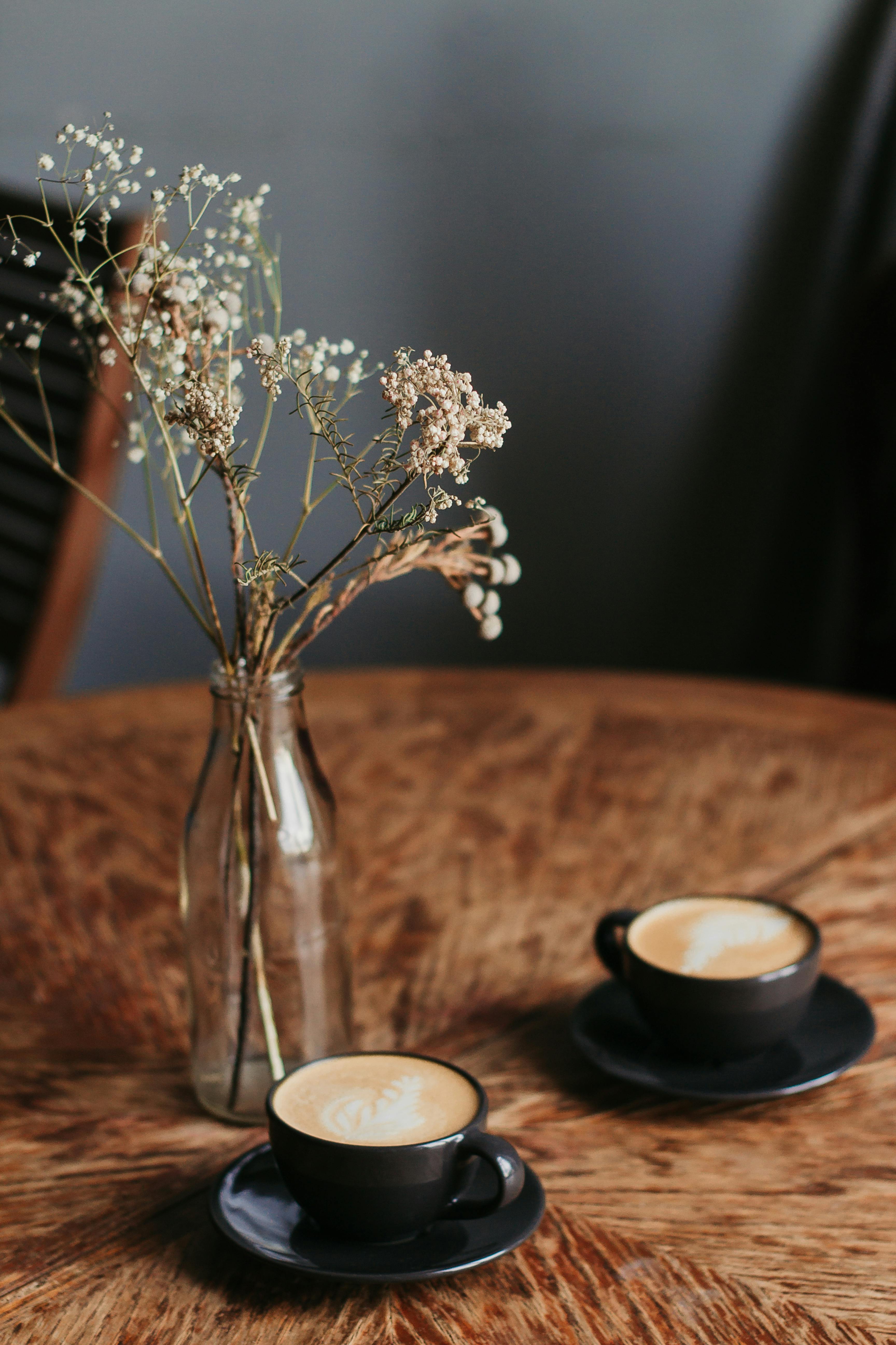 Two Coffee Cups Beside Flower Vase · Free Stock Photo