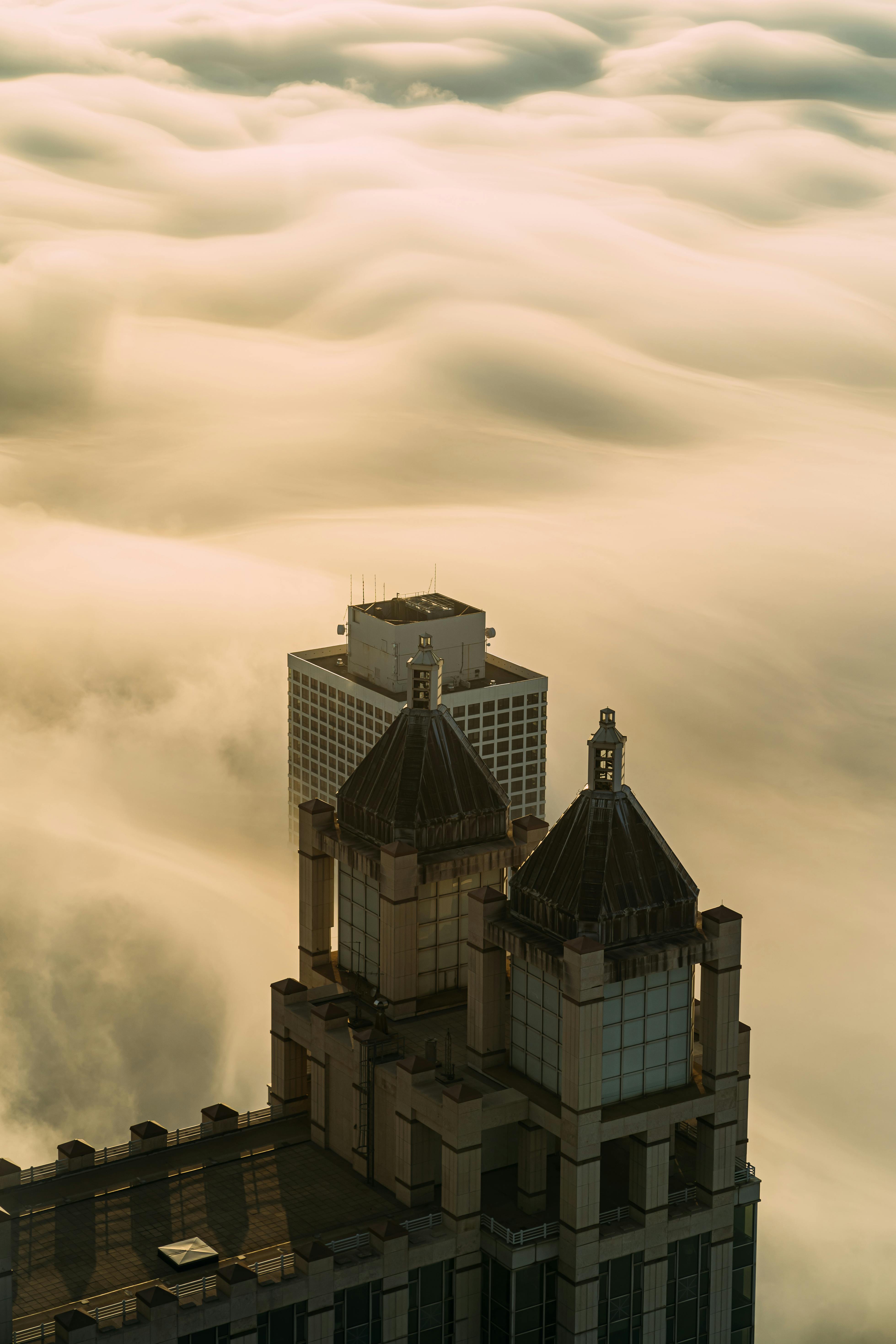 日出时，摩天大楼透过低洼云层窥视的景色十分迷人