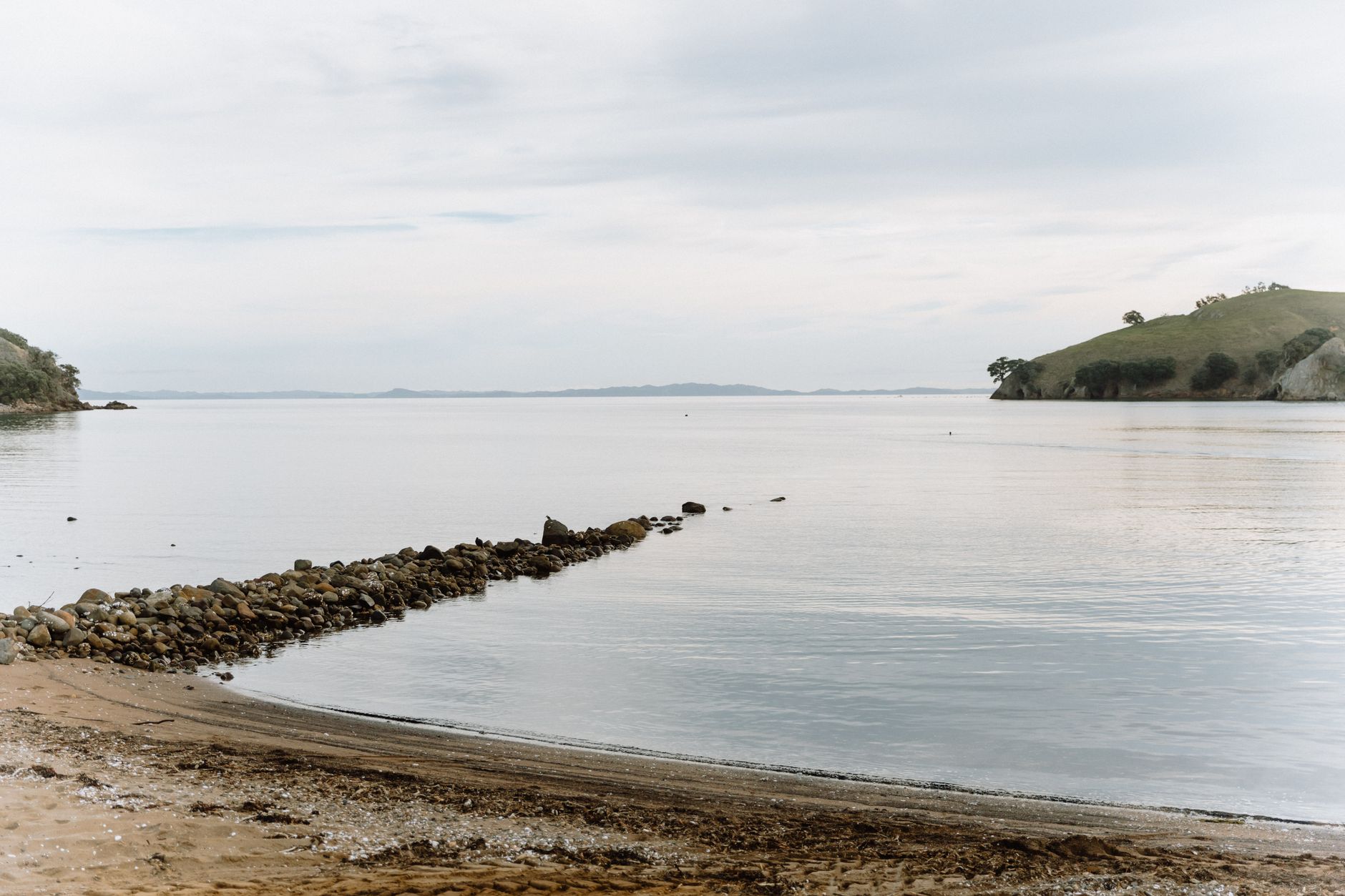 Peaceful beach and calm water at Kereta, Waikato, New Zealand, showcasing coastal beauty.