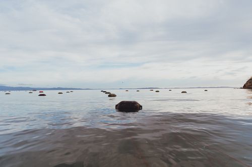 Free Tranquil scene of buoys floating in calm sea in Kereta, Waikato, New Zealand. Stock Photo