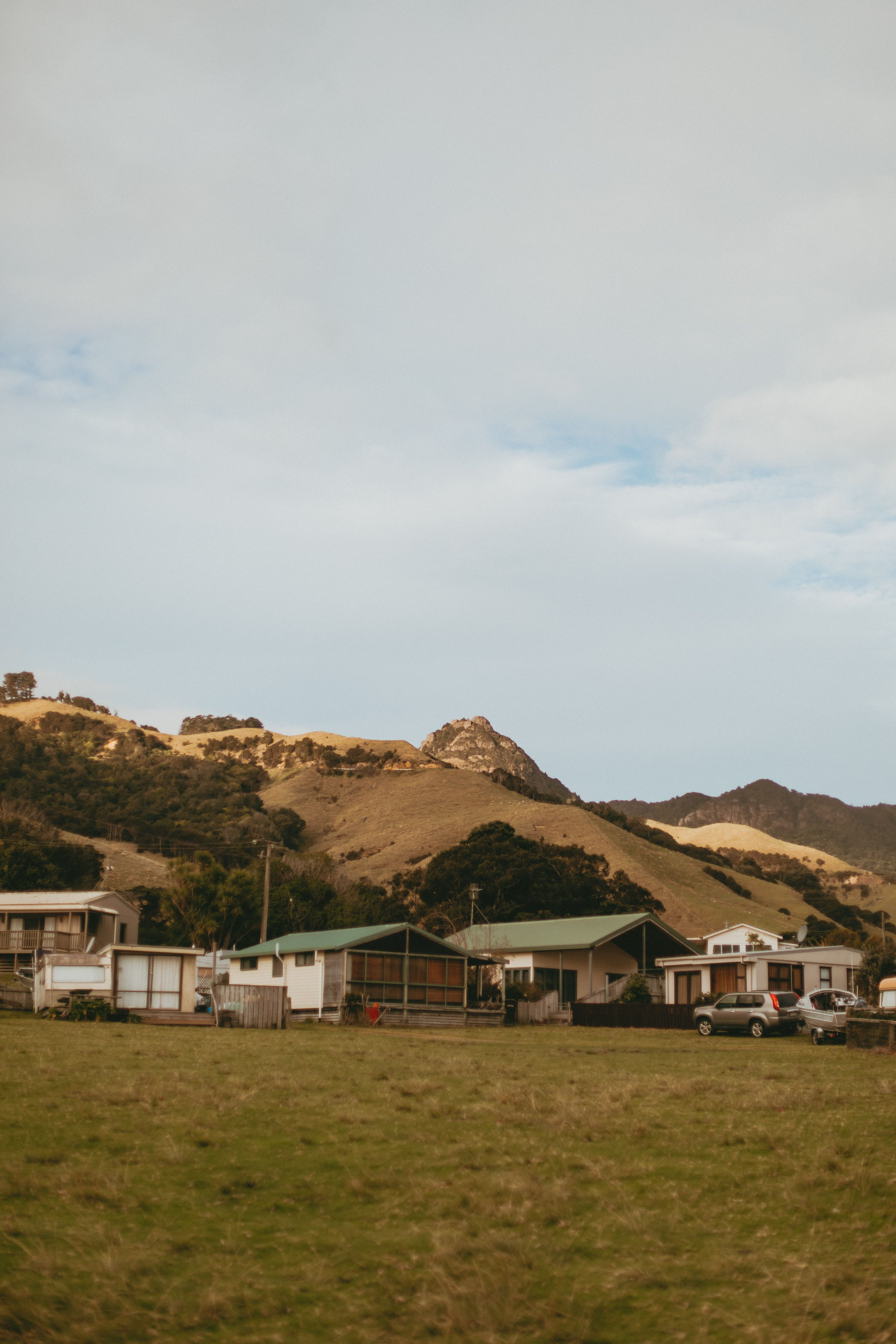 Picturesque rural setting with hills and houses in Coromandel, New Zealand. Ideal for travel and landscape themes.