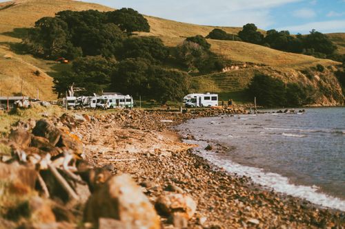 Free Relaxing coastal camping scene with RVs along the Coromandel beach in New Zealand. Stock Photo