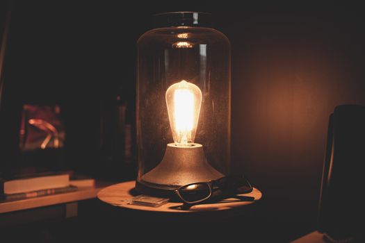 Warm glow of a vintage Edison bulb in a glass dome, creating a cozy ambiance.