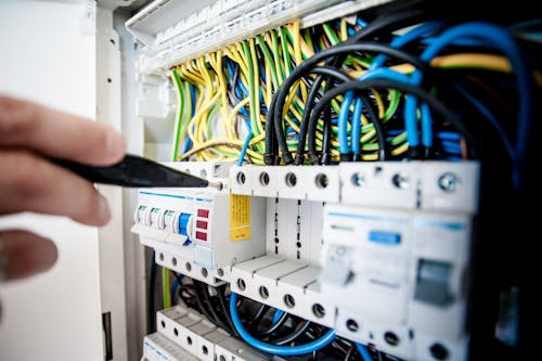 Free Electrician Fixing an Opened Switchboard Stock Photo