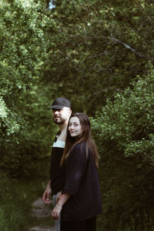 Free A couple walking through a verdant forest in France, surrounded by lush greenery. Stock Photo