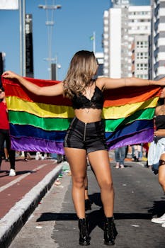 在巴西圣保罗的骄傲游行上，一名妇女高兴地挥舞着彩虹旗