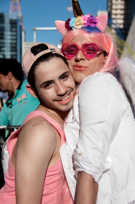 Two people dressed in vibrant outfits celebrating LGBT pride in São Paulo.
