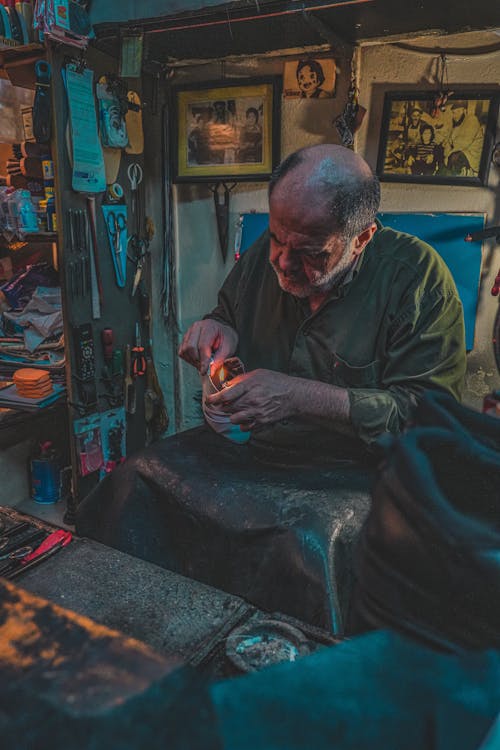 A man is working on his jewelry in his shop