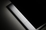 在暗色调的工作室环境中，一台采用时尚极简主义设计的封闭笔记本电脑被突出展示，强调其设计感