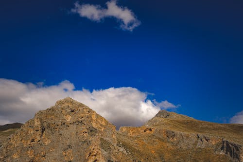 A mountain with a blue sky and clouds