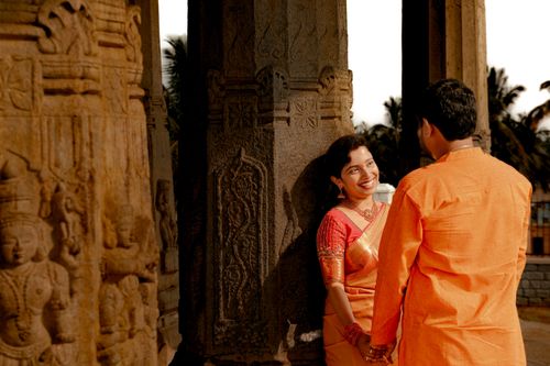 Free A couple in traditional attire shares a moment at ancient temple ruins, smiling warmly. Stock Photo