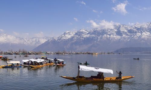 Free Peaceful boats on Dal Lake with snow-capped mountains in Srinagar, India. Stock Photo