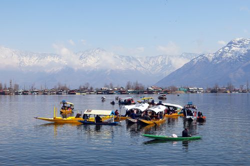 Free Beautiful scene of Dal Lake in Srinagar with colorful shikaras and snow-capped mountains in the background. Stock Photo