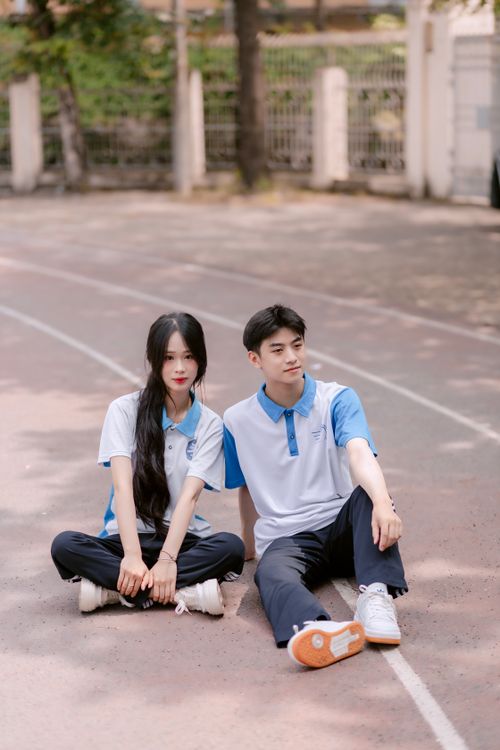 Free Two young athletes in sportswear sitting on outdoor track, serene expression. Stock Photo
