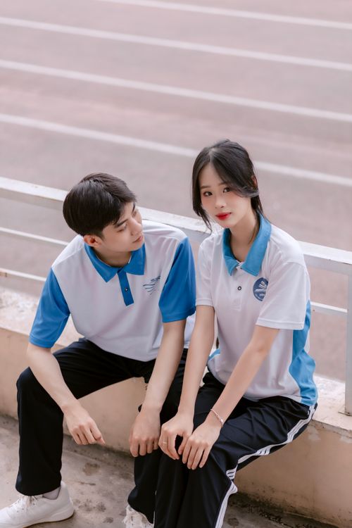 Free Two young athletes in matching sportswear sitting together at a sports ground. Stock Photo