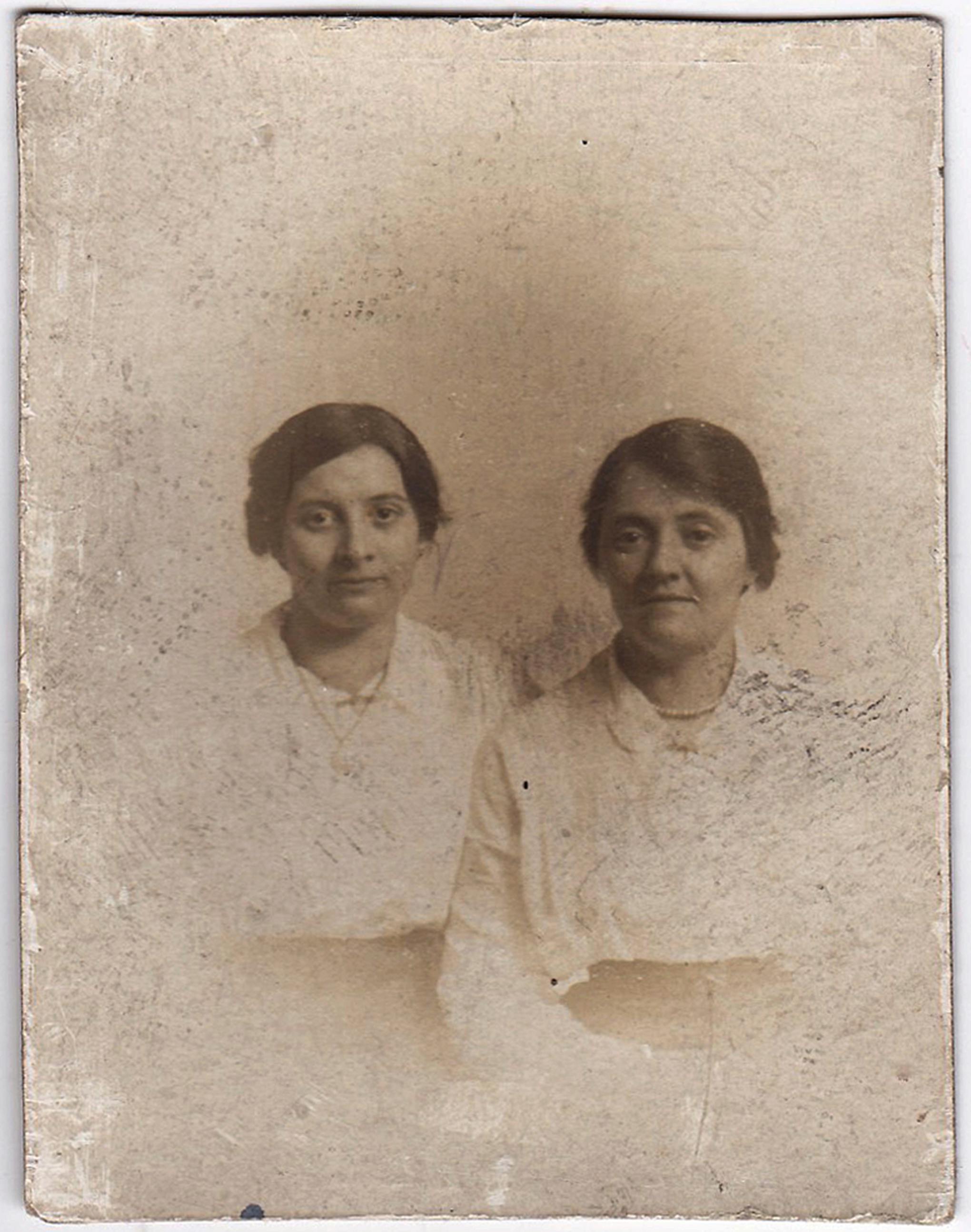 A classic vintage sepia portrait of two women with subtle smiles.