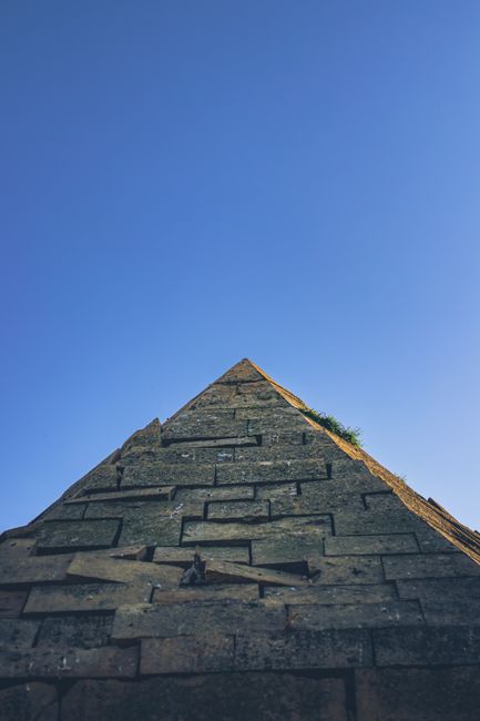 View of a towering stone pyramid with clear blue sky, showcasing its ancient architecture.