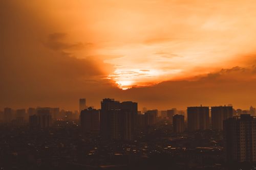 Free A mesmerizing view of a city skyline under a fiery orange sunset, creating a dramatic atmosphere. Stock Photo