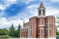 在部分多云的天空下，雄伟的砖砌教堂塔楼显得格外突出