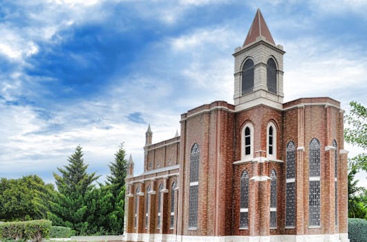 在部分多云的天空下，雄伟的砖砌教堂塔楼显得格外突出