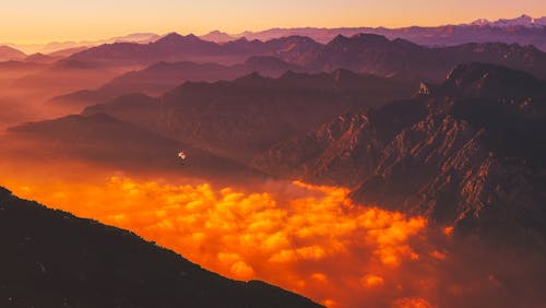 Gratis Pemandangan Indah Pegunungan Melawan Langit Dramatis Saat Matahari Terbenam Foto Stok