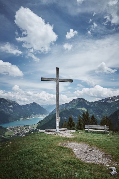 Free Cross overlooking the stunning landscape of Pertisau, Tirol with mountains and dramatic clouds. Stock Photo