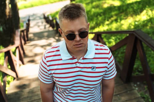 A man in sunglasses and a striped polo shirt