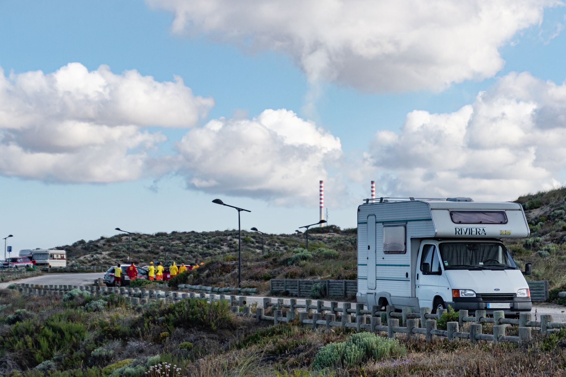 Camper geparkeerd in het schilderachtige landschap van Portugal onder een heldere blauwe lucht met fluffy wolken.