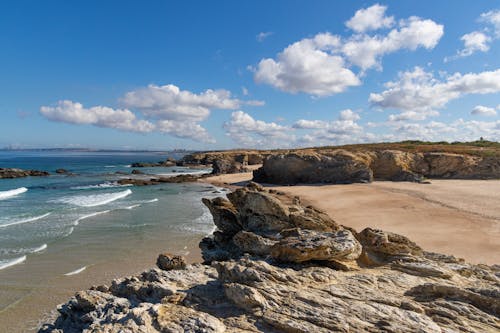 Photo of Rock Boulders in Shore Under Blue Sky