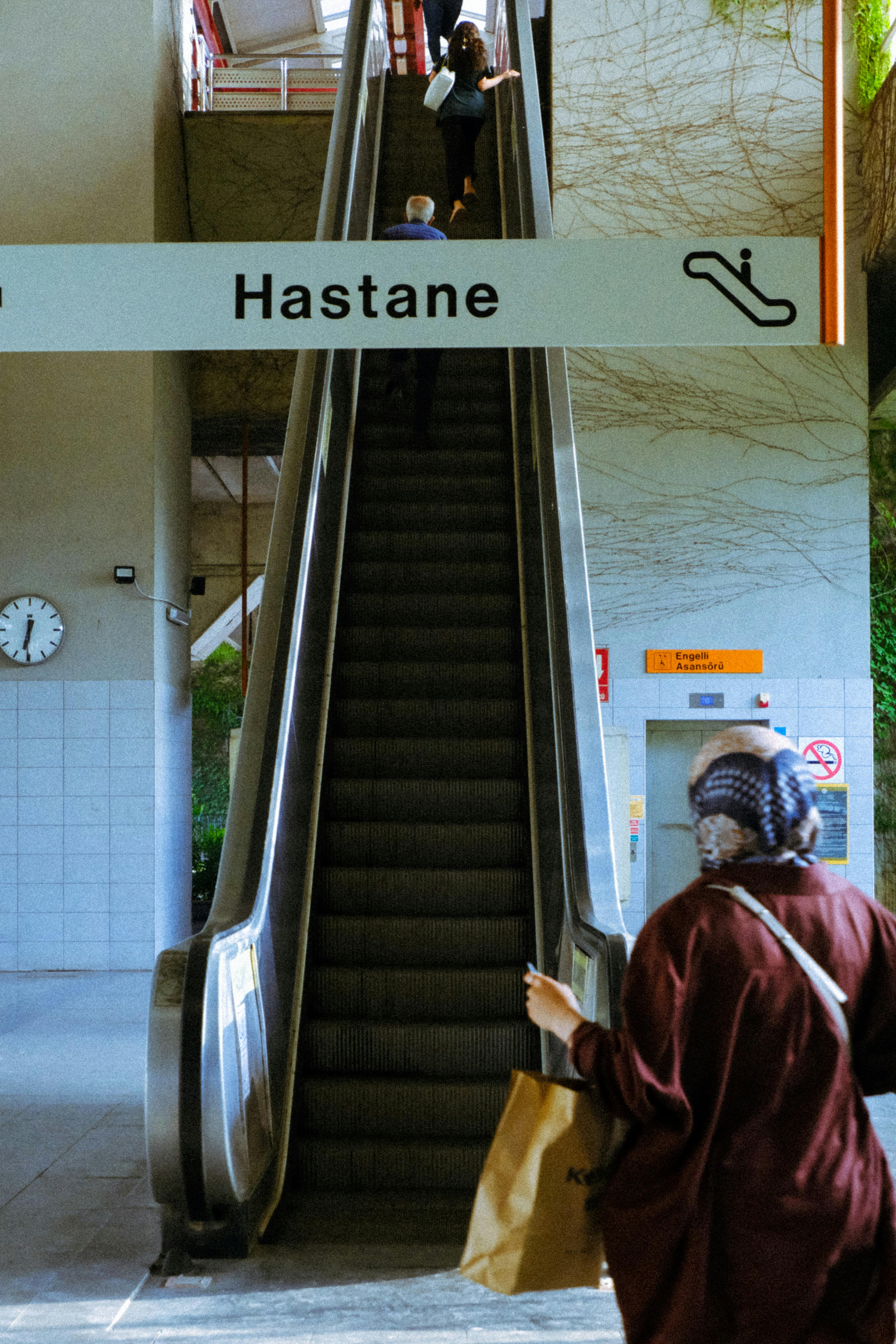 Escalator in urban setting leading to 'Hastane'. A view of city transportation hub.