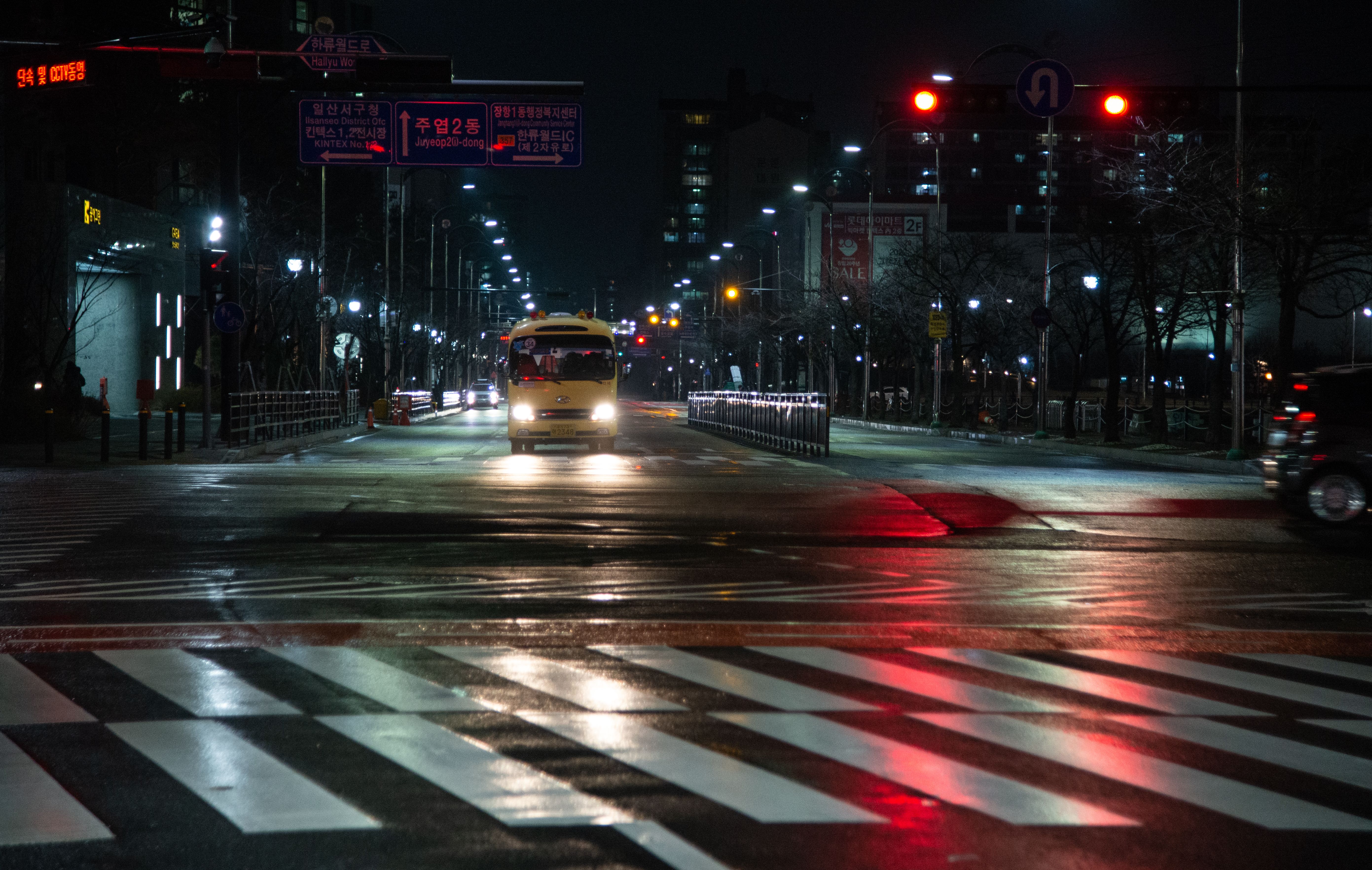 A bus is driving down a street at night · Free Stock Photo