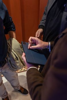 Men interacting with a tablet indoors, highlighting modern technology and connectivity.