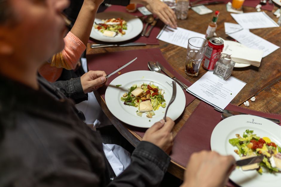 Grupo disfrutando de tapas y vinos en una mesa grande en España