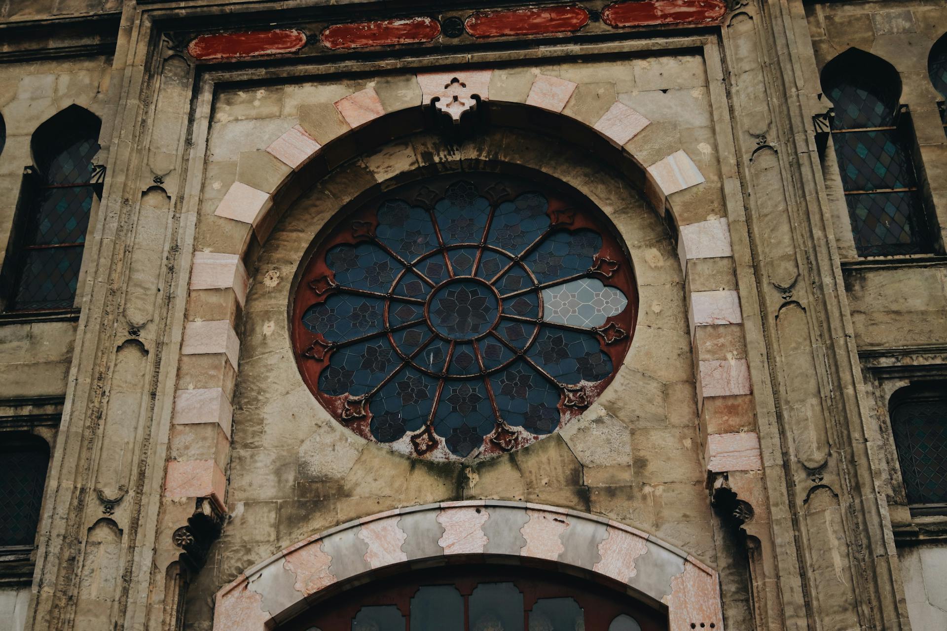 A detailed shot of a historic building facade featuring an ornate circular window design.