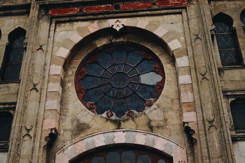 Free A detailed shot of a historic building facade featuring an ornate circular window design. Stock Photo