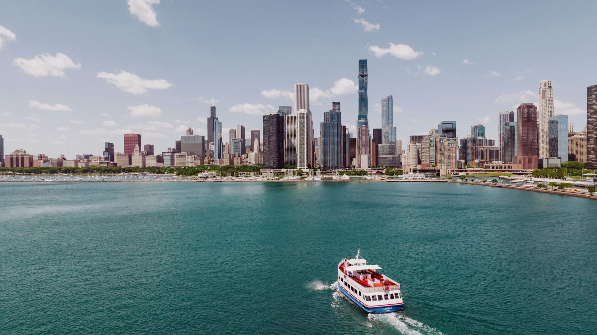 Scenic view of Chicago skyline with a boat on Lake Michigan during day.