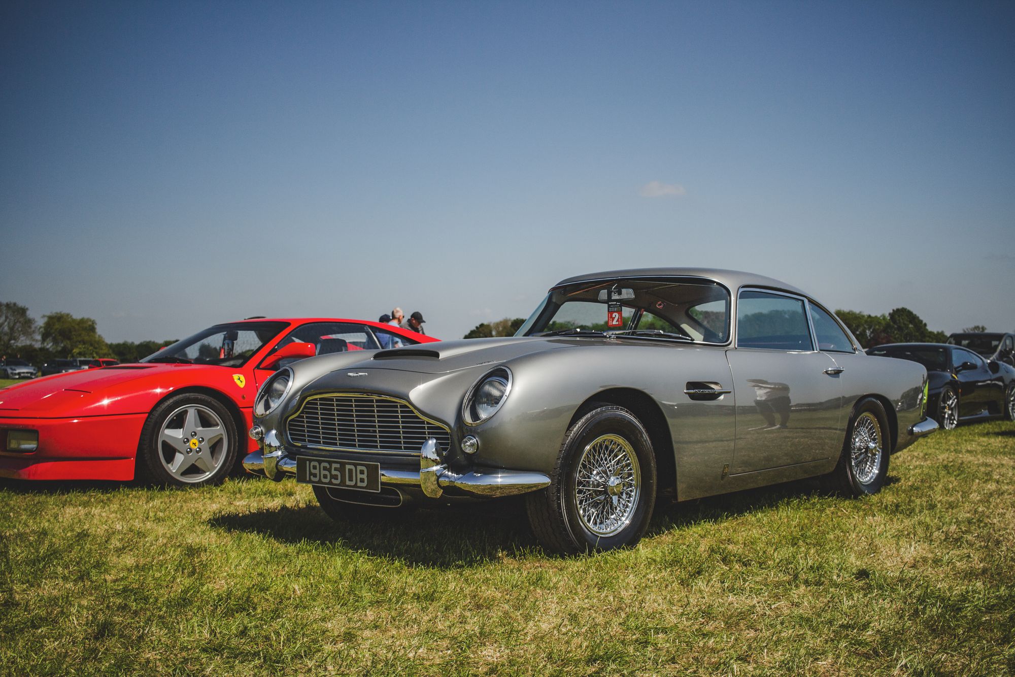Silver Aston Martin DB5 in period-correct form prominently displayed, closely matching the article