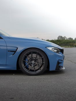 Close-up of a parked modern blue car outdoors showcasing its sleek design and performance features.