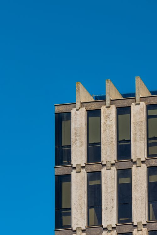 Free Close-up of a modern office building facade with clear blue sky. Stock Photo