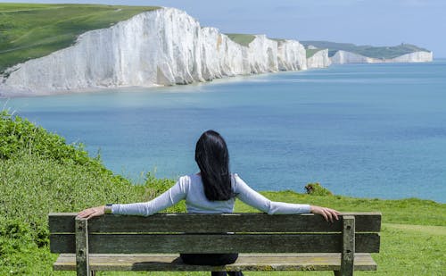 海沿いのデッキチェアに座っている女性