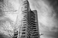 现代玻璃摩天大楼与引人注目的云层相映，构成了一幅引人注目的黑白景观