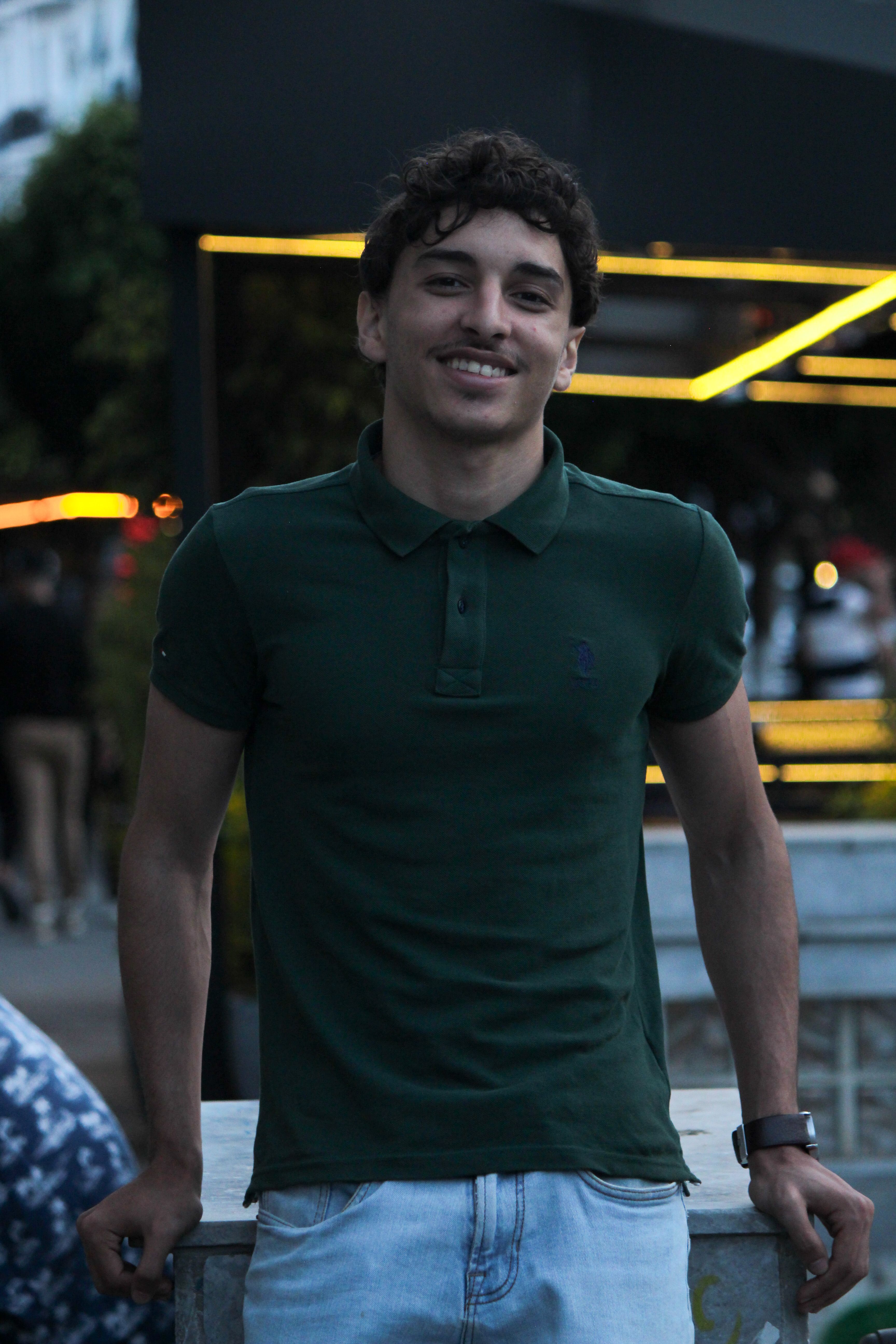 Portrait of a smiling man in a green polo shirt outdoors in Alger Centre, Algeria.