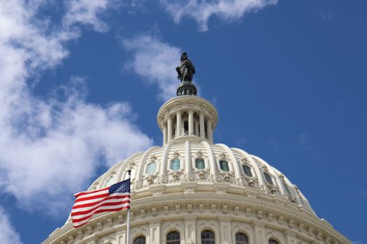 Capture of the U.S. Capitol dome with an American flag waving against a blue sky in Washington, D.C.