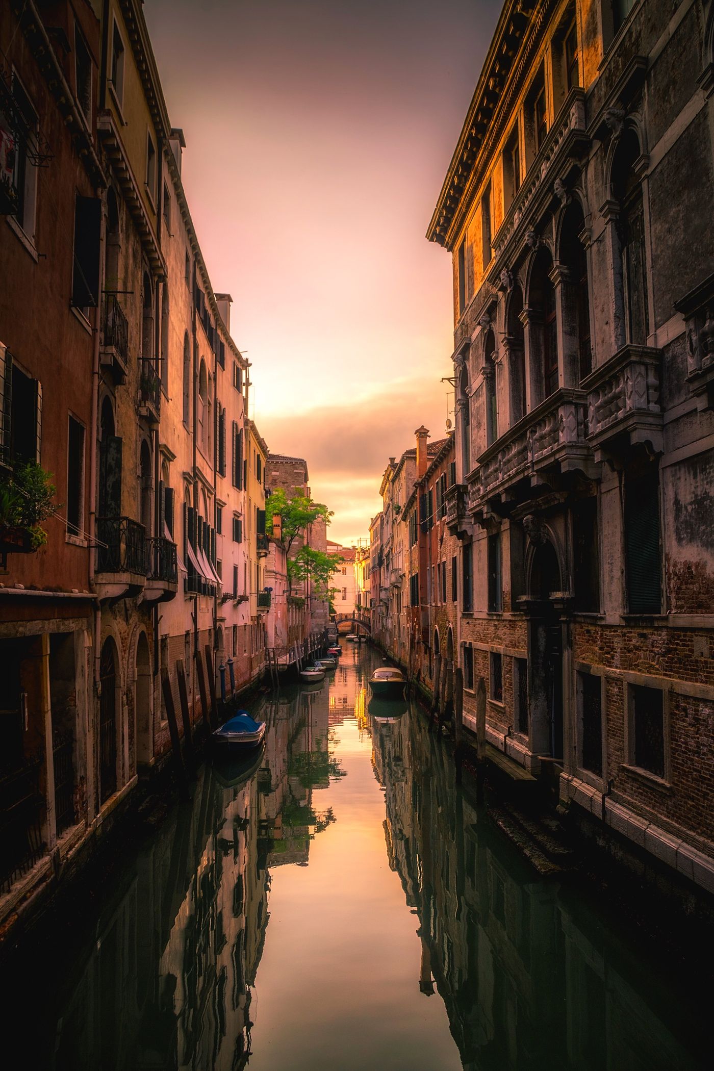 A quiet canal between old buildings at sunset.