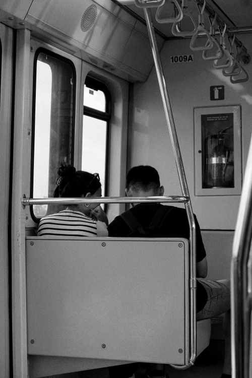 Free A couple sits together on a train, captured in black and white, showcasing travel and connection. Stock Photo